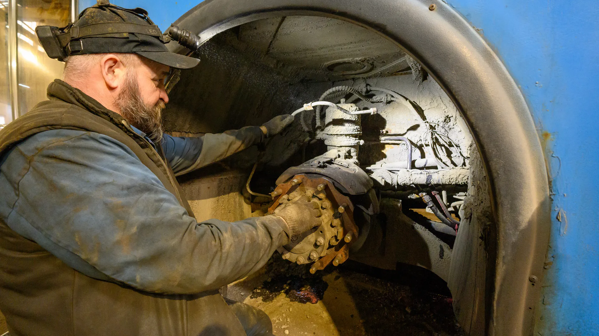 Автомеханик проводит технический осмотр автобуса перед отправлением в рейс