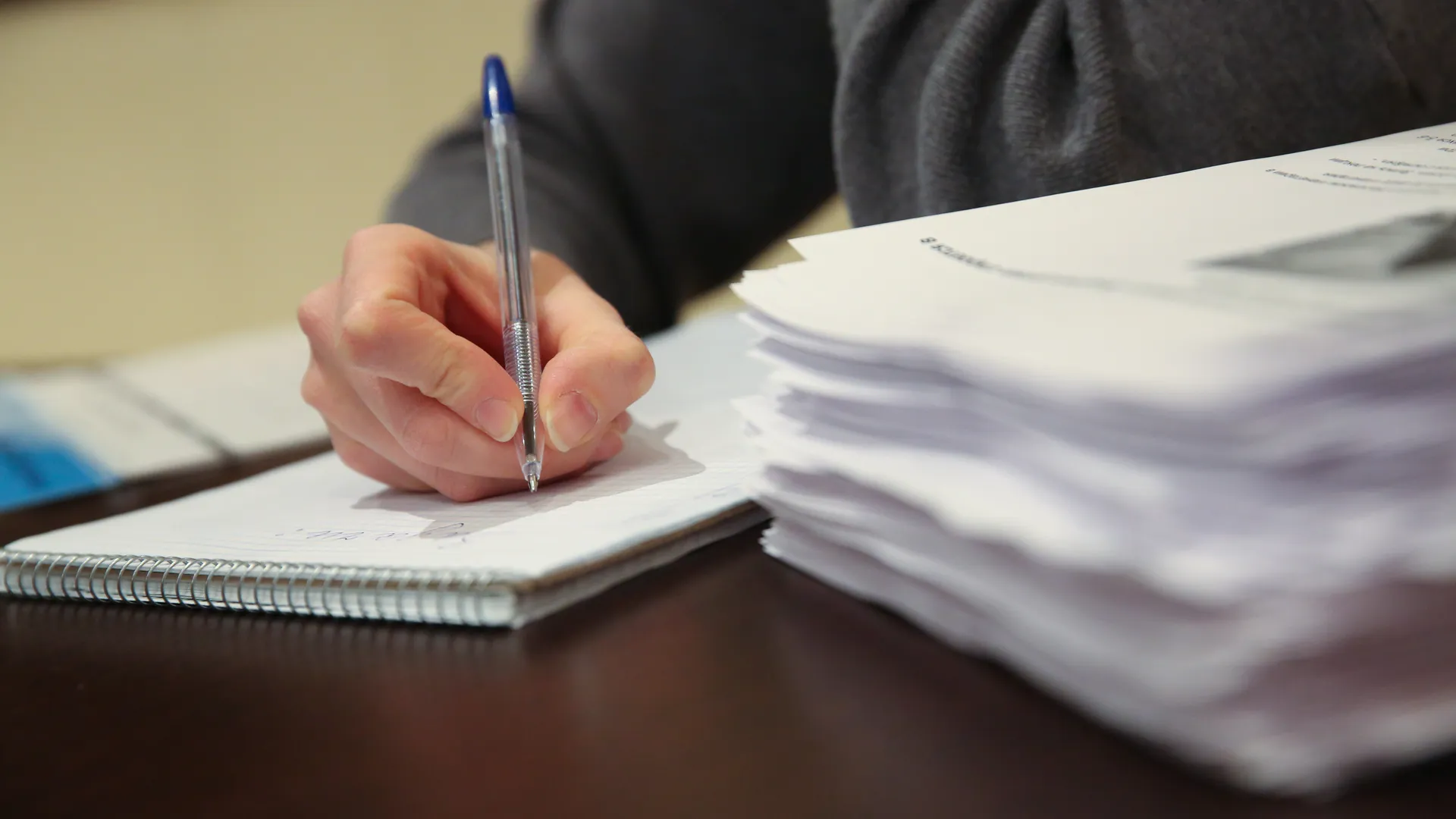 Девушка делает записи в тетради