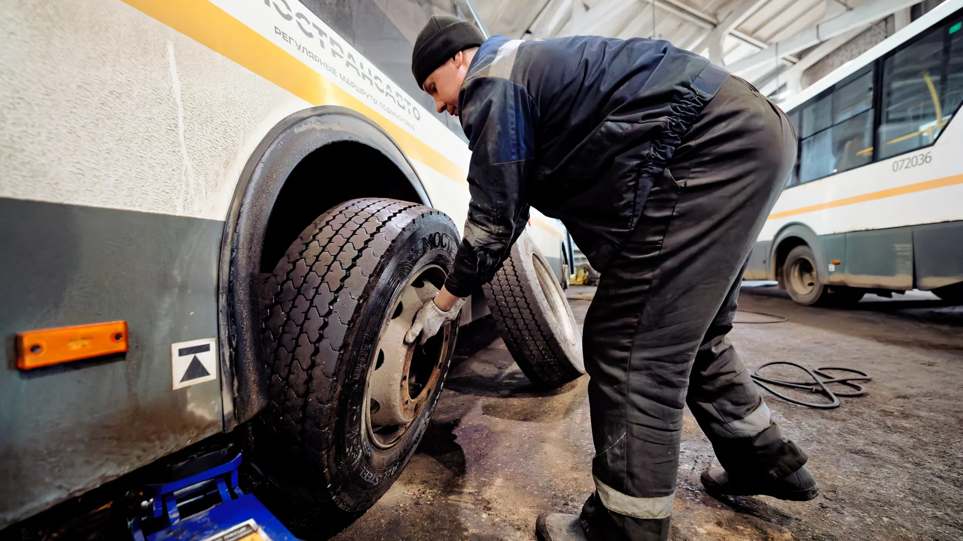 Автомеханик проводит технический осмотр автобуса перед отправлением в рейс